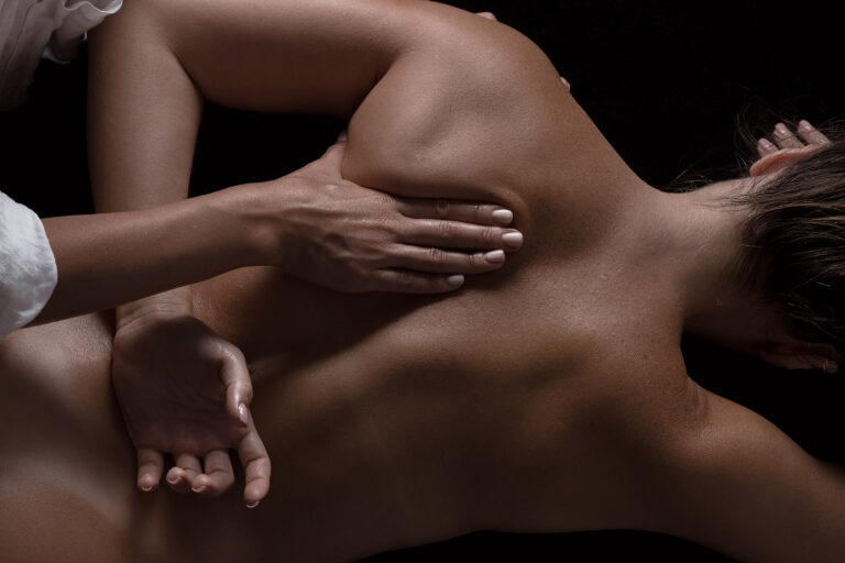masseur girl makes a massage close-up on a dark background. close-up massage